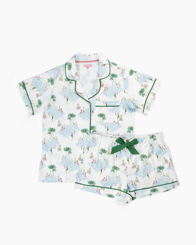 The Zertz PALM COURTS PAJAMA SHORT SET features an elastic waist, white fabric with a colorful poolside print, green piping and bow. Includes a button-up shirt and shorts that can be personalized with a monogram.