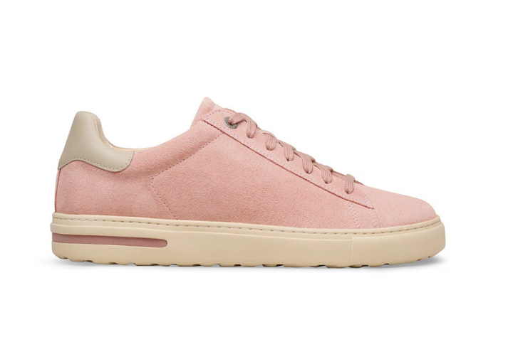 The Zertz BEND LOW PINK CLAY OYSTER 1032085 sneaker features a pink suede upper, beige sole, matching heel tab, and pink laces. Shown in side profile on a white background. Designed for comfort and shock absorption with every step.