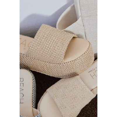 Close-up of several Zertz PISMO PLATFORM SANDALS in beige, featuring textured fabric, open toes, and flatform soles. Overlapping angles highlight the subtle woven jute patterns on the stylish vegan material.
