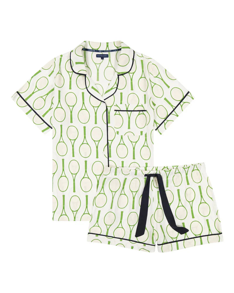 The Zertz TENNIS TIME PAJAMA SHORTS SET is a white women’s short-sleeve set with matching shorts, green tennis racket print inspired by an American Summer, black trim, chest pocket detail, and a black drawstring.