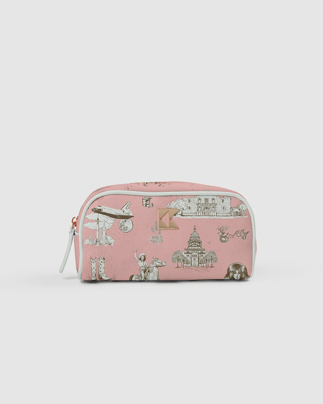 The Zertz THE PETITE ACCESSORY BAG TEXAS TOILE is a pink travel pouch with white side panels, featuring illustrations of an airplane, cowboy boots, a dog, a statue, and a domed building—perfect for organizing essentials on the go.