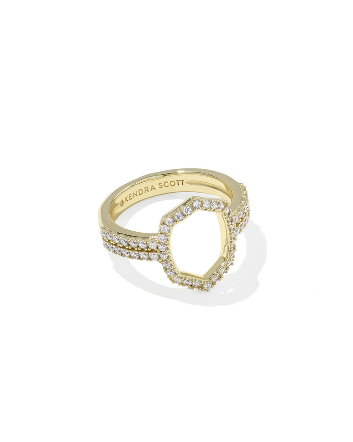 The Zertz DAPHNE PAVE COCKTAIL RING is a gold ring with pavé clear stones, a hexagonal open center, and “Zertz” engraved inside the band. Shown on a white background, it’s a stunning statement piece.