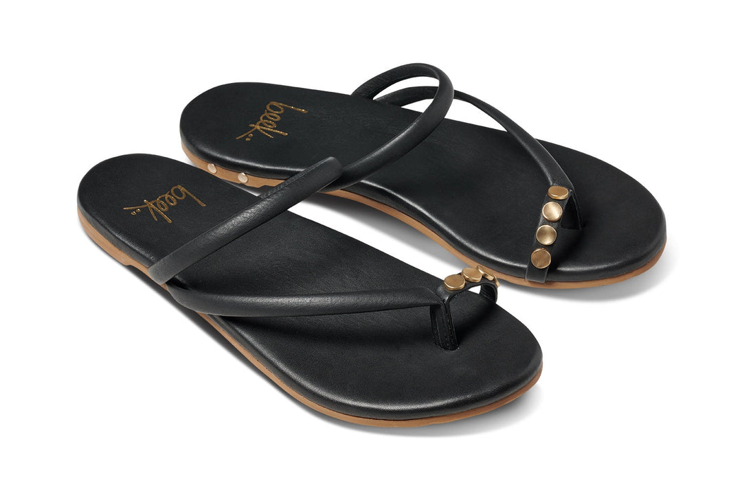 The Zertz STARBIRD TOE RING SANDAL is a chic minimalist black sandal with thin straps, gold studs on the sides, a brown sole, and gold bodoy branding—perfect for summer.