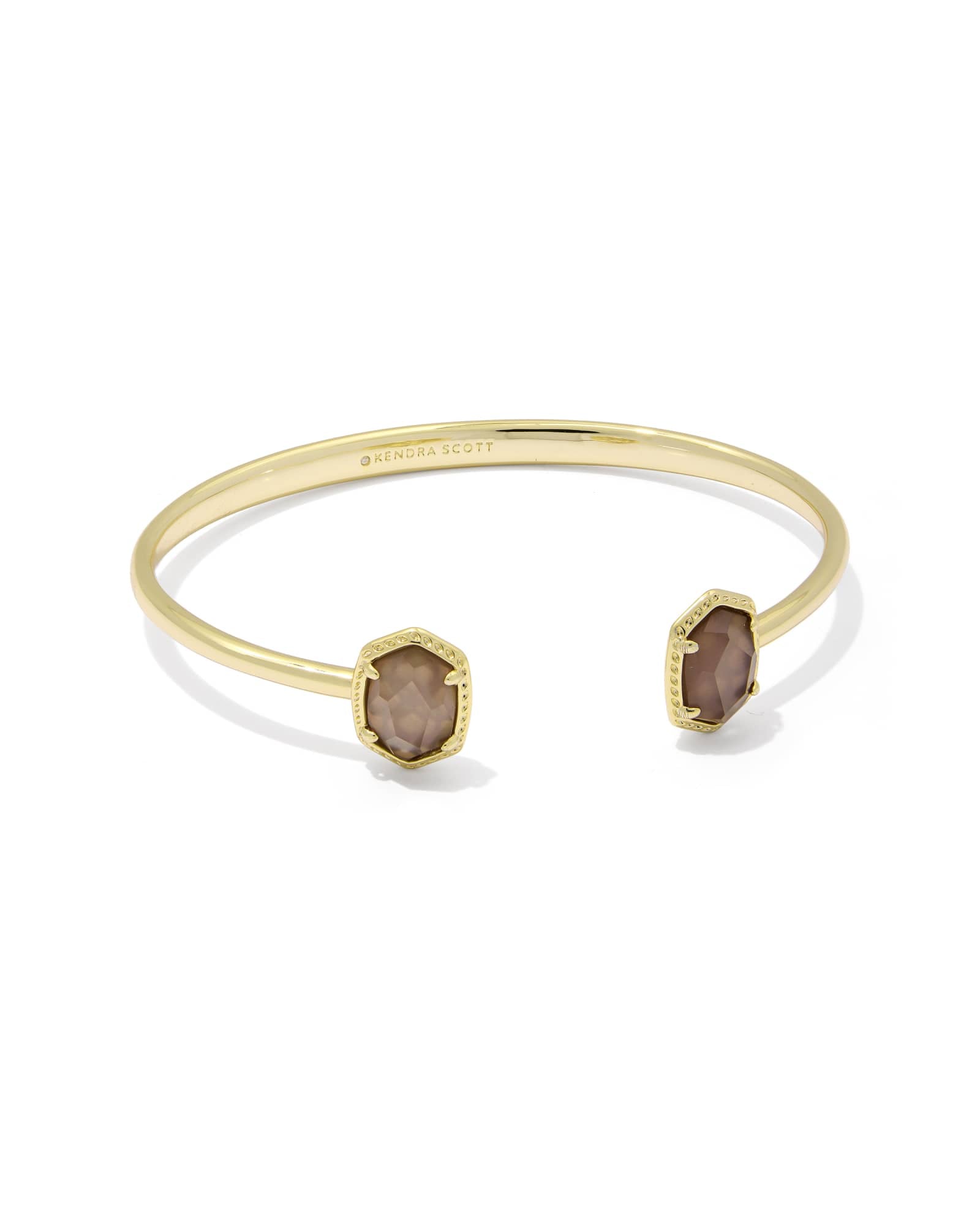 The Zertz DAPHNE FRAME CUFF BRACELET in TAUPE MOP features two hexagonal stones at each end and a structured, minimalist design—an elegant gold accessory to elevate any look.
