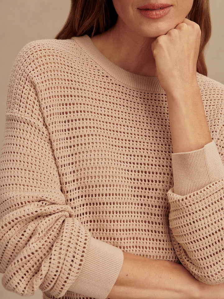 A person wearing the Zertz KERSHAW SWEATER TOP in light beige, featuring a cozy knit and textured pattern. The cropped image focuses on the upper body and part of the face, highlighting this versatile piece.