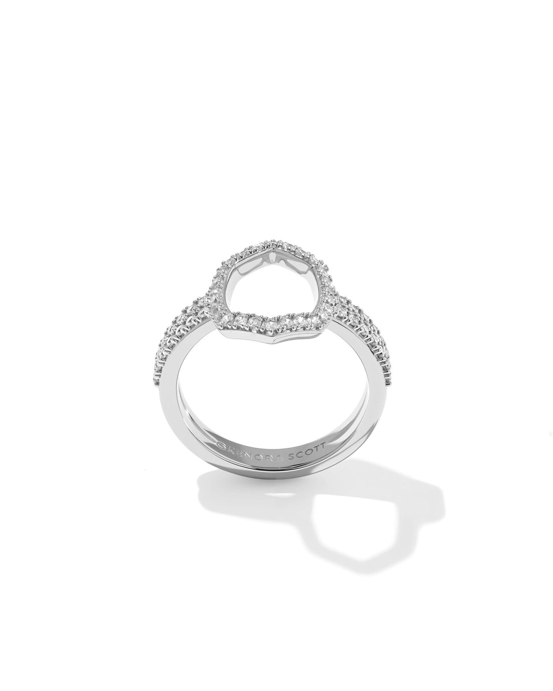 The DAPHNE PAVE COCKTAIL RING by Zertz features pavé detailing in an open heart shape, casting a delicate shadow on a white background. The brand name Zertz is elegantly etched on the white gold band.