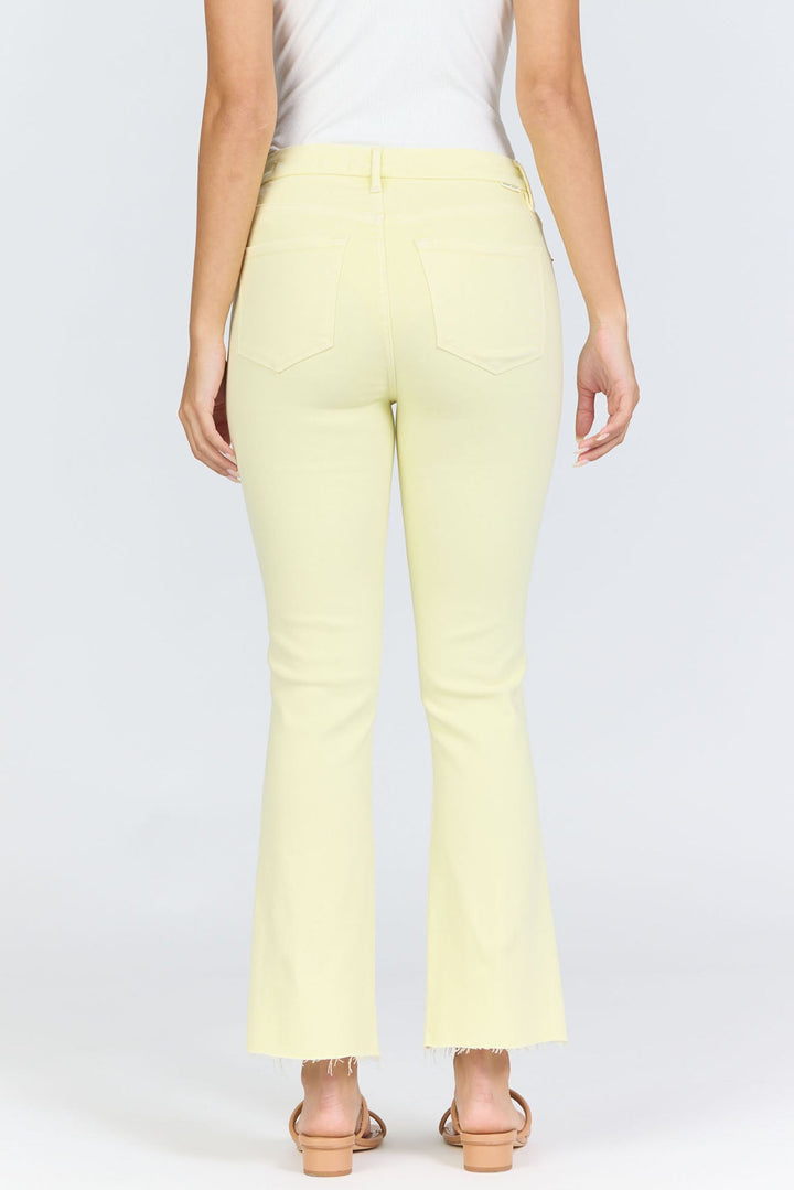 A person wearing Zertz JEANNE JEAN in pale yellow—slightly flared with raw hems, classic back pockets, and a timeless silhouette—paired with a white sleeveless top and open-toe sandals, seen from the back to show the comfy fit.