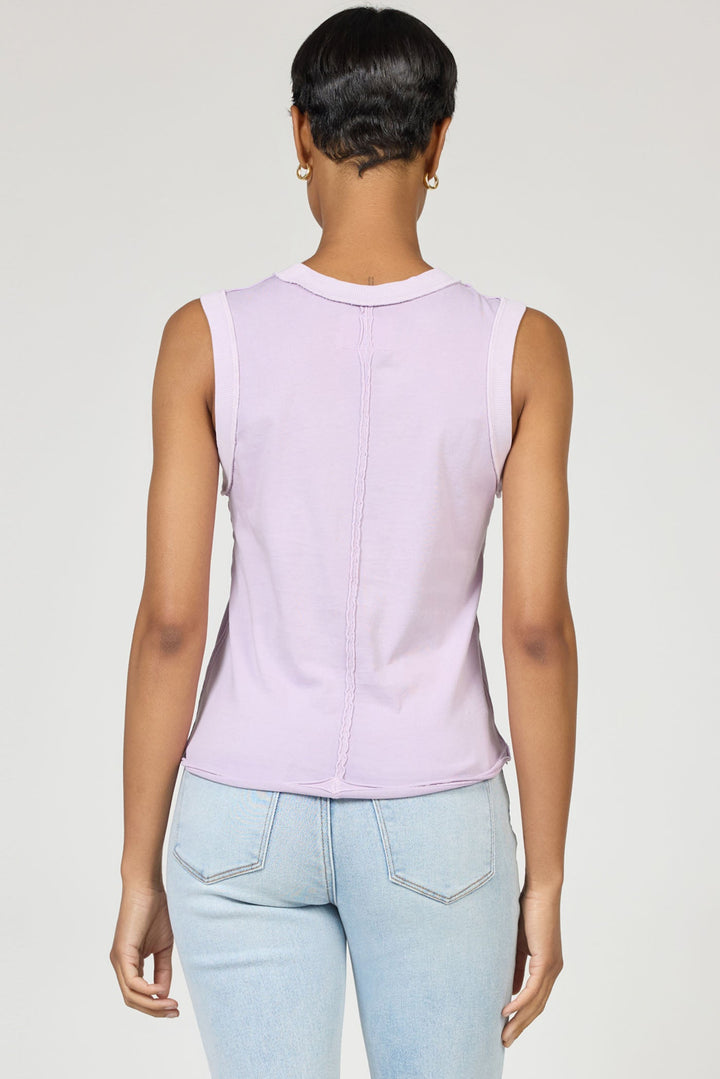 A person with short hair is seen from behind, wearing a sleeveless lavender Zertz ZO TANK made from breathable fabric and light blue jeans against a plain light background.